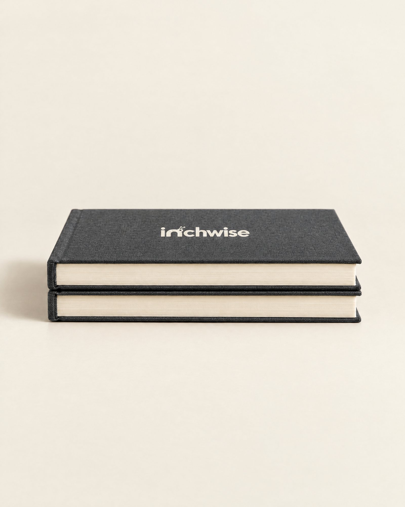 Two Inchwise journals stacked, showing the cream page edges
